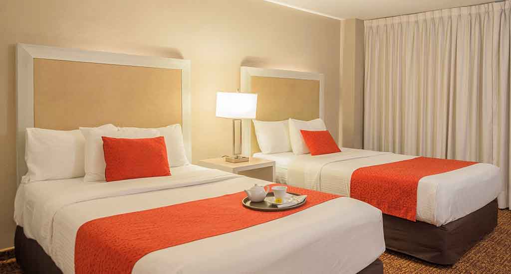 Slaapkamer met twee bedden in Stanza Hotel in Mexico City