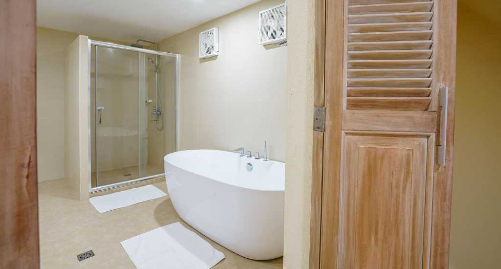 Badkamer met douche en bad in Coco Grove beach resort in Siquijor